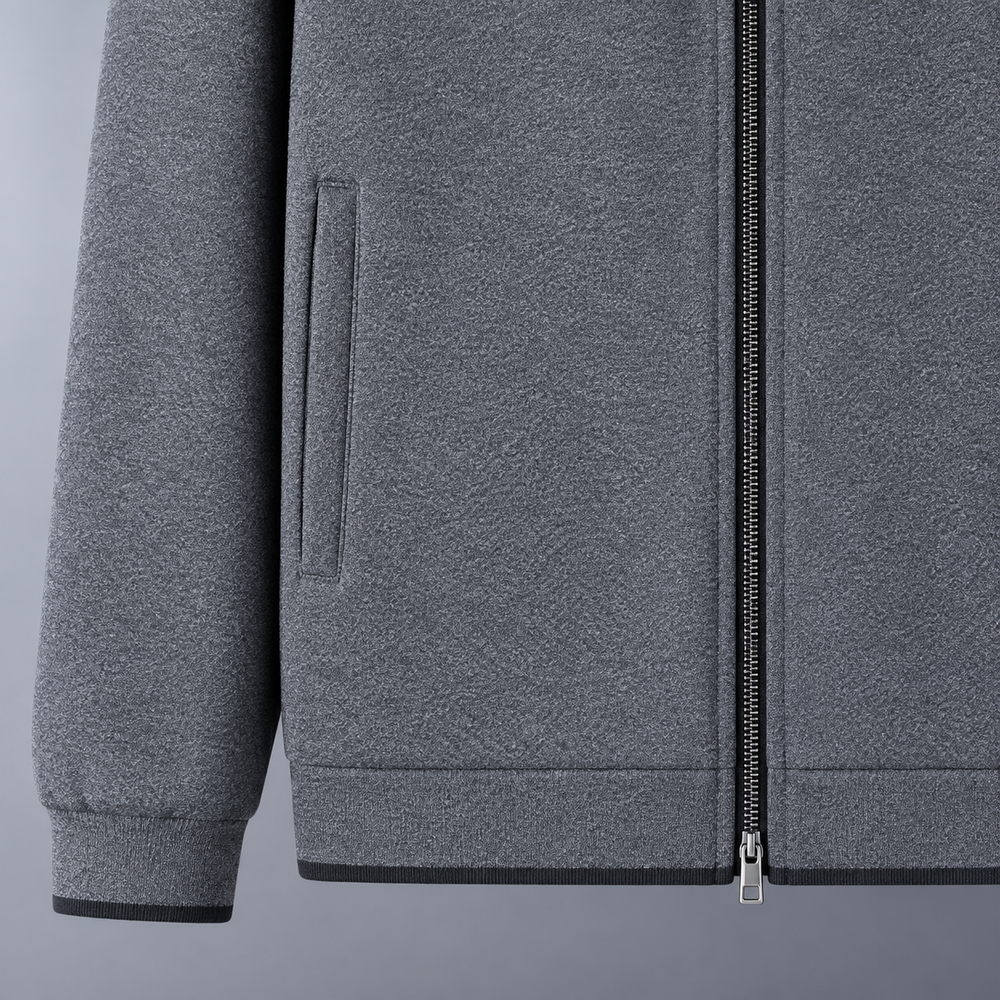 Close view of gray Monza track jacket pocket, zipper, and hem