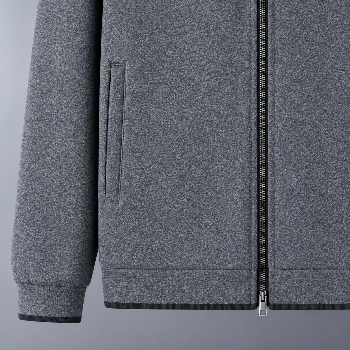 Close view of gray Monza track jacket pocket, zipper, and hem